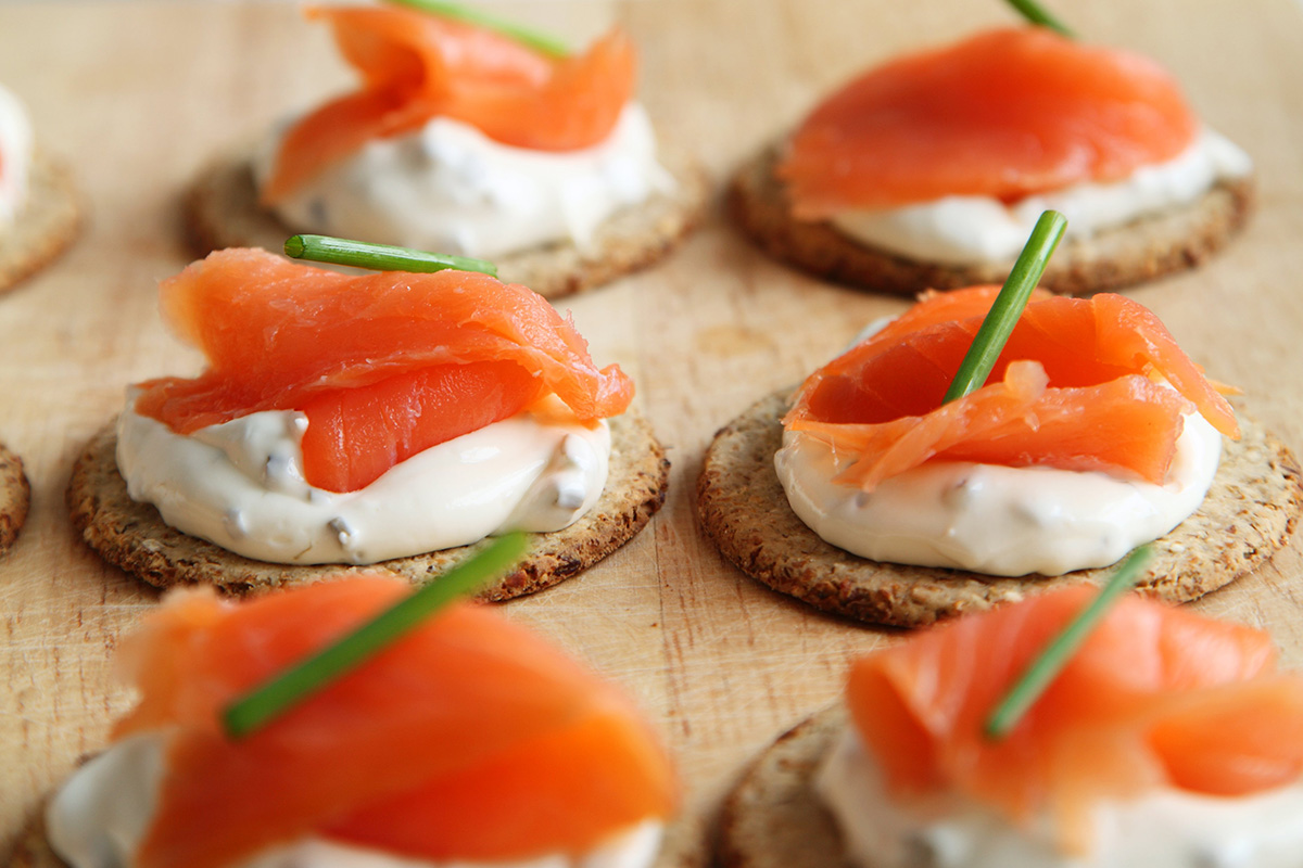 ¡Los snacks ligeros siempre triunfan! Puedes preparar platos tan sencillos como estas deliciosas tostadas con queso cremoso y salmón.