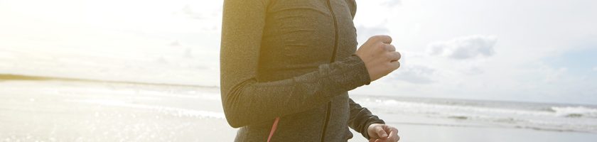 Close up portrait of a young woman jogging on the beach