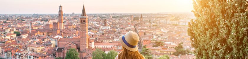 Woman enjoying beautiful view on Verona city in Italy on the sunset. Verona is famous city of love in the north of Italy.